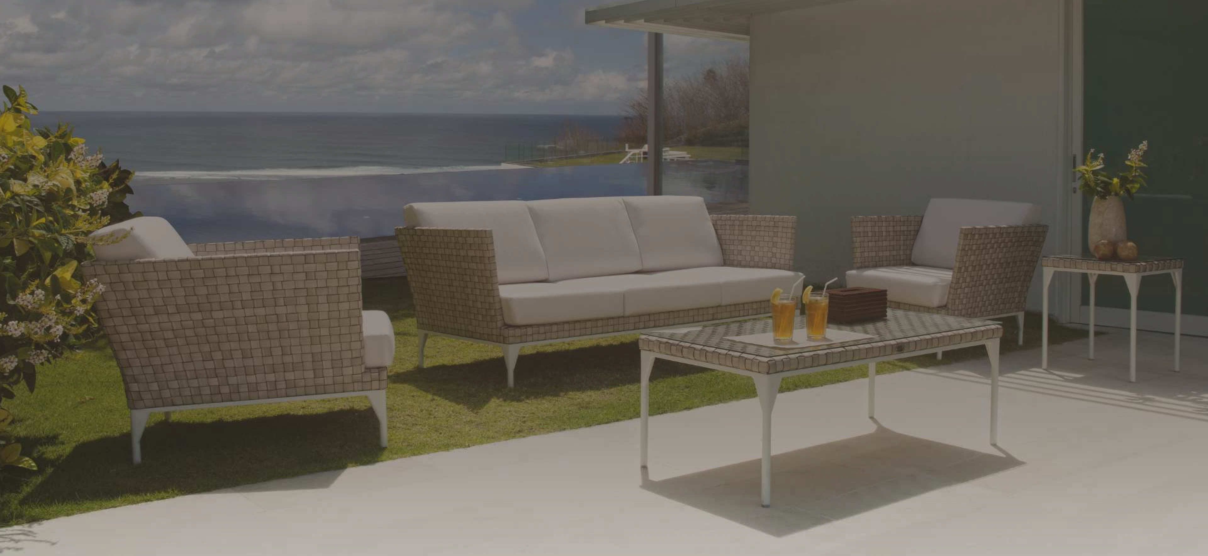 Outdoor patio furniture set with a scenic view of water and mountains.